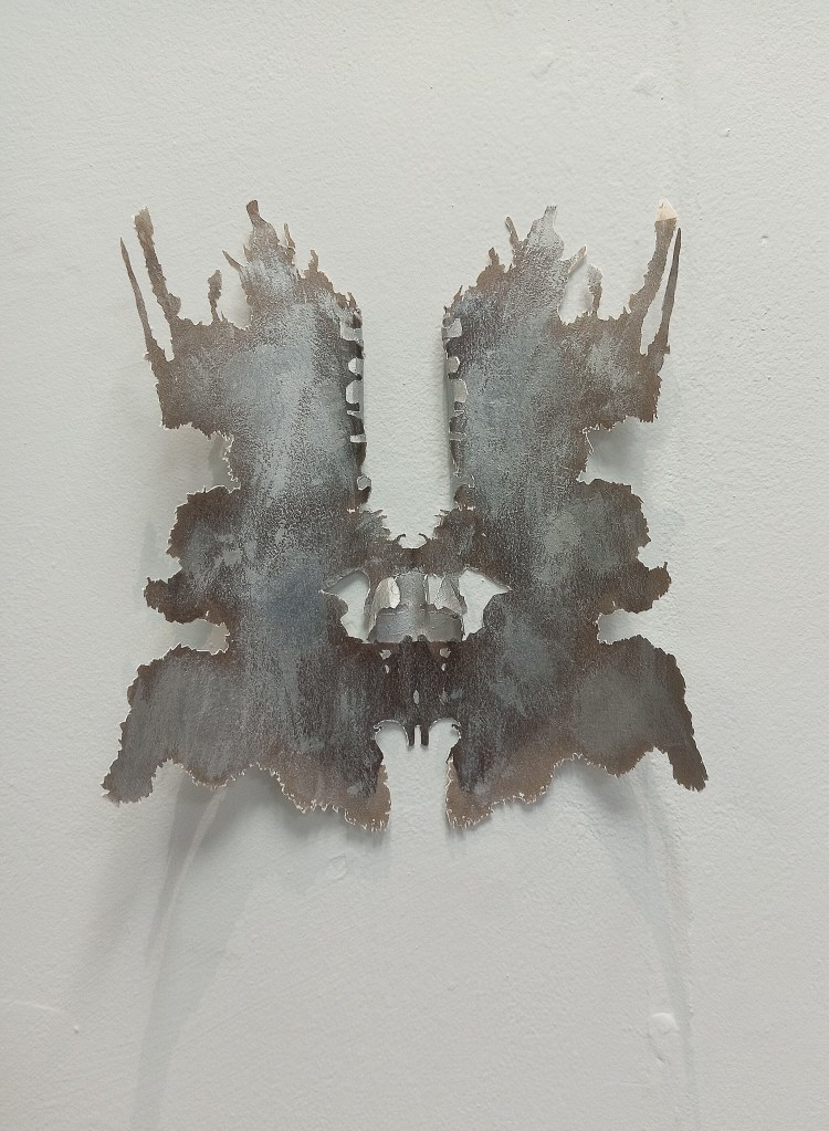 Untitled 1 ©Mary Sheehan, a smokey grey Rorschach cutout form attached to a white paper background giving a 3D effect and shadows.